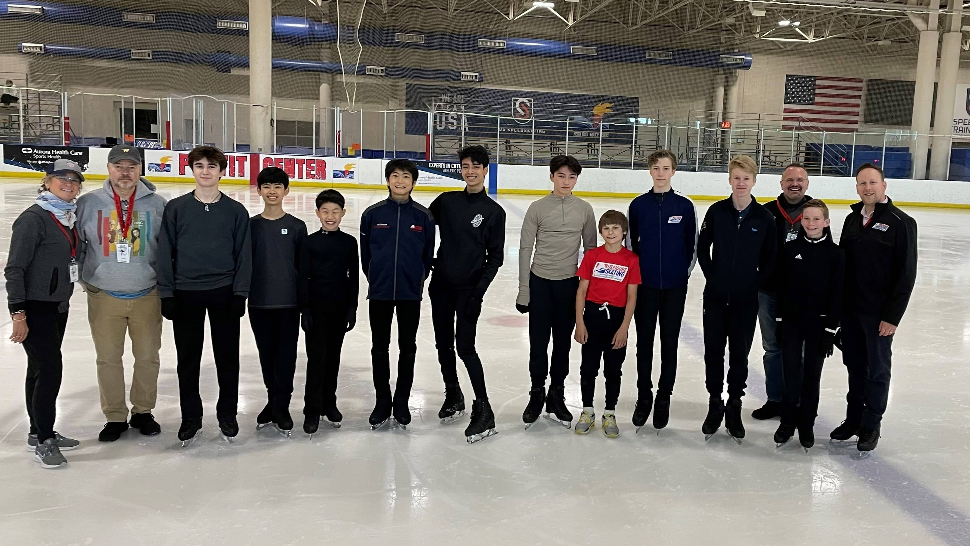 A group of male skaters together on the ice.